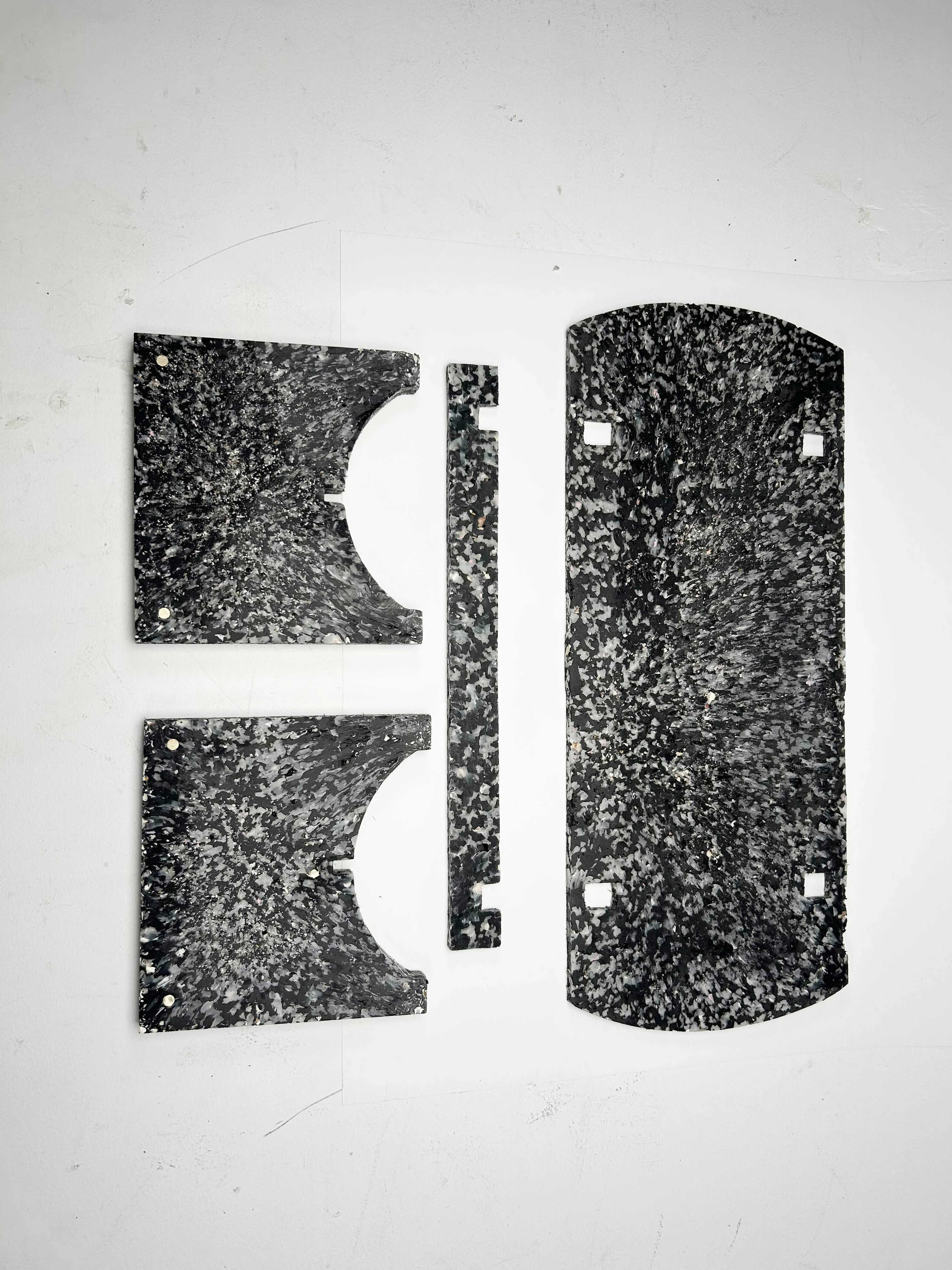 The four flat-pack components of the bench laid out, showing the terrazzo-like shell composite.